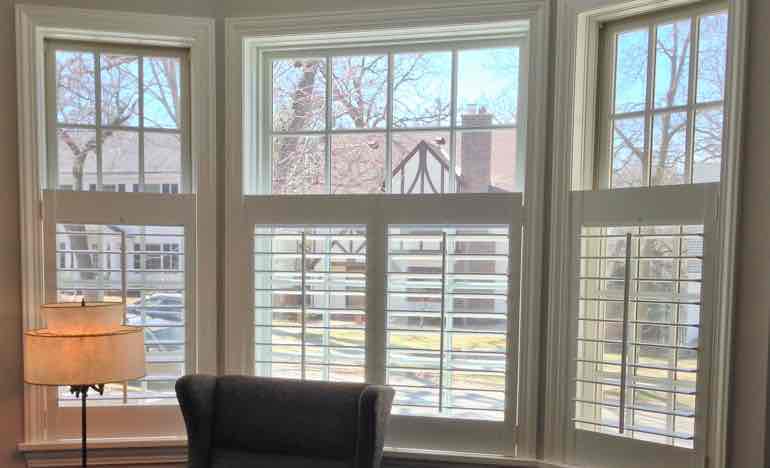 Half-length insulating shutters in living room bay window.